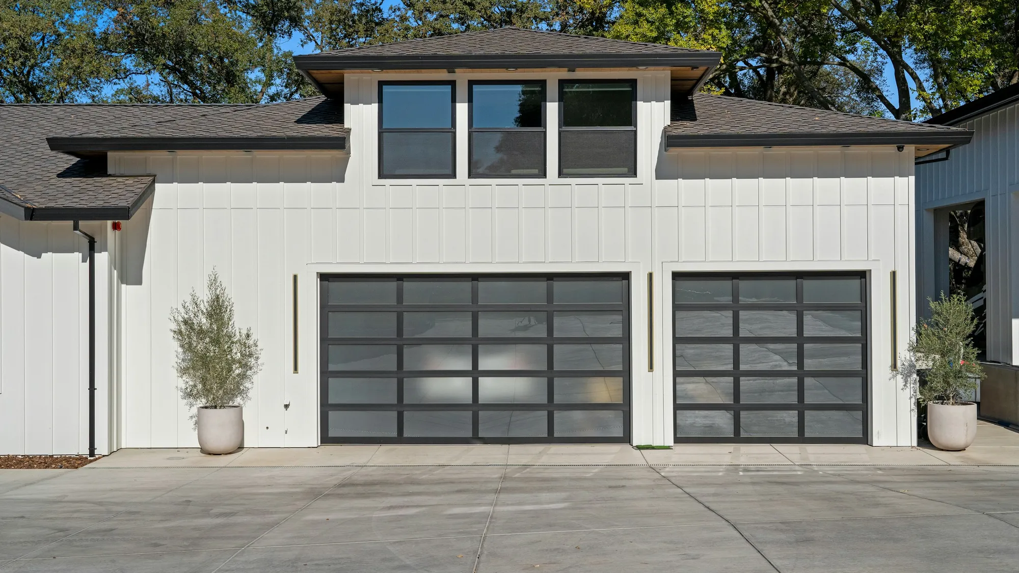 Modern black glass garage doors on a white home